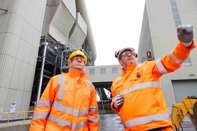 image of two men in hi-vis in front of a building
